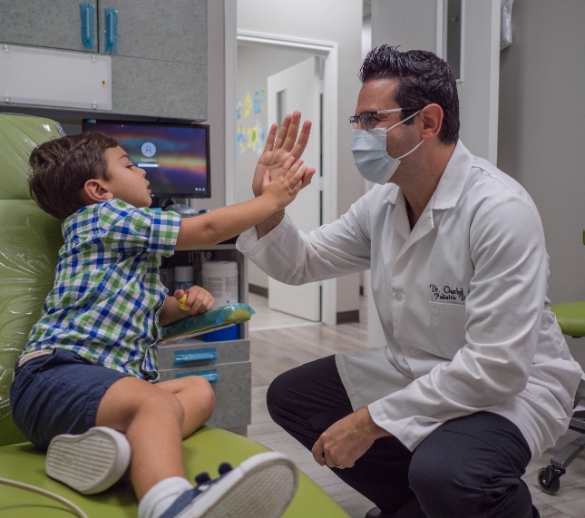 pediatric dentist in spring branch tx high fiving child in office