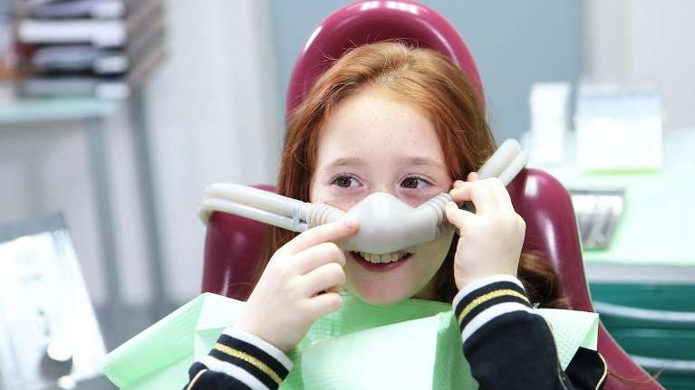 young girl wearing nitrous oxide | pediatric dentist 77055