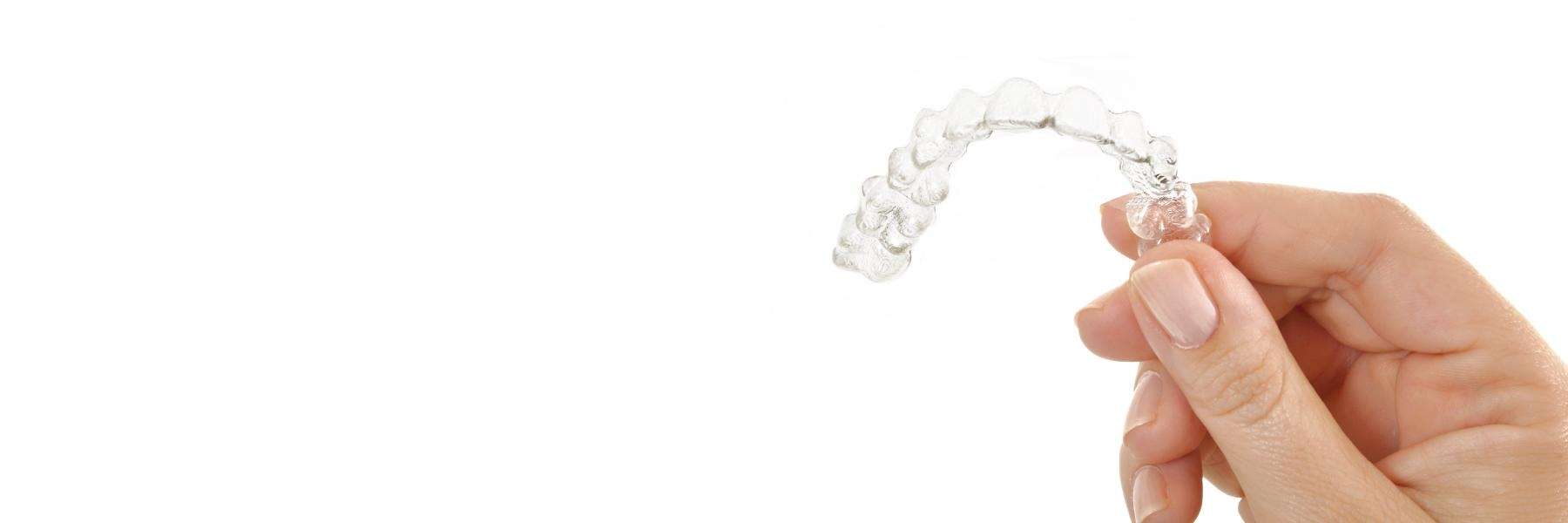 person holding aligner for Invisalign for kids